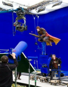 Actor flying on broomstick.