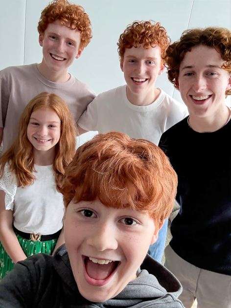 A selfie of the Weasley siblings altogether in a cozy room.