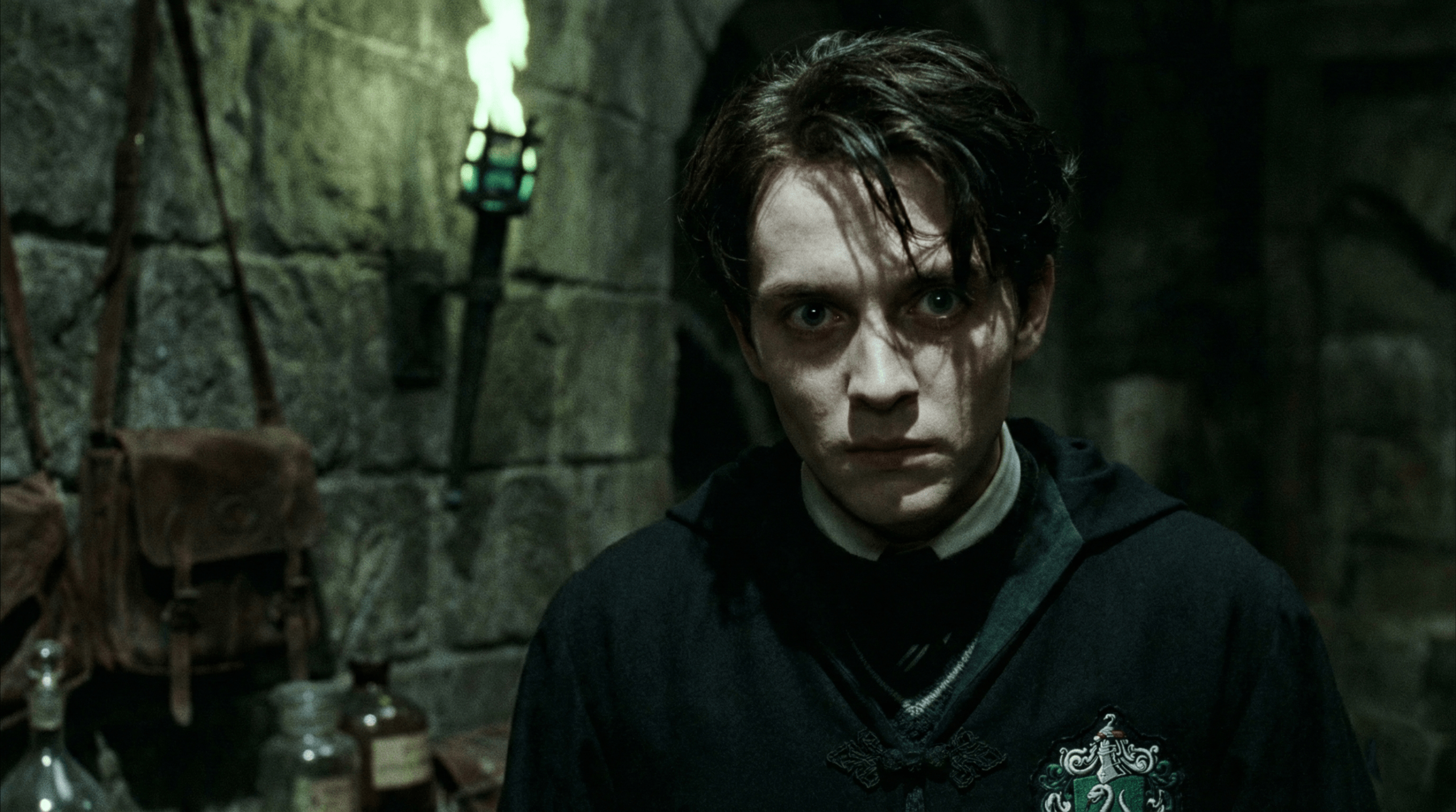 Young Barty Crouch Jr. as a fanatical Death Eater in dark robes, intense expression in dimly lit dungeon